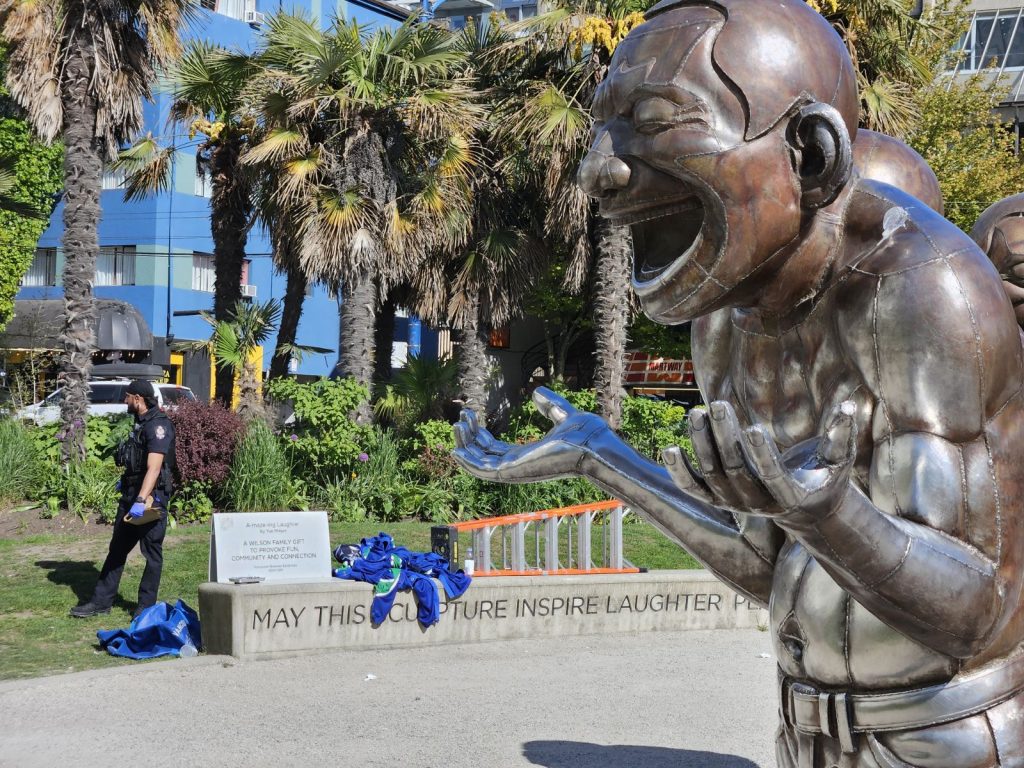 Vancouver Canucks jerseys on English Bay Laughing Men statues burned