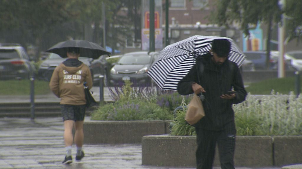 People in Vancouver carry umbrellas.