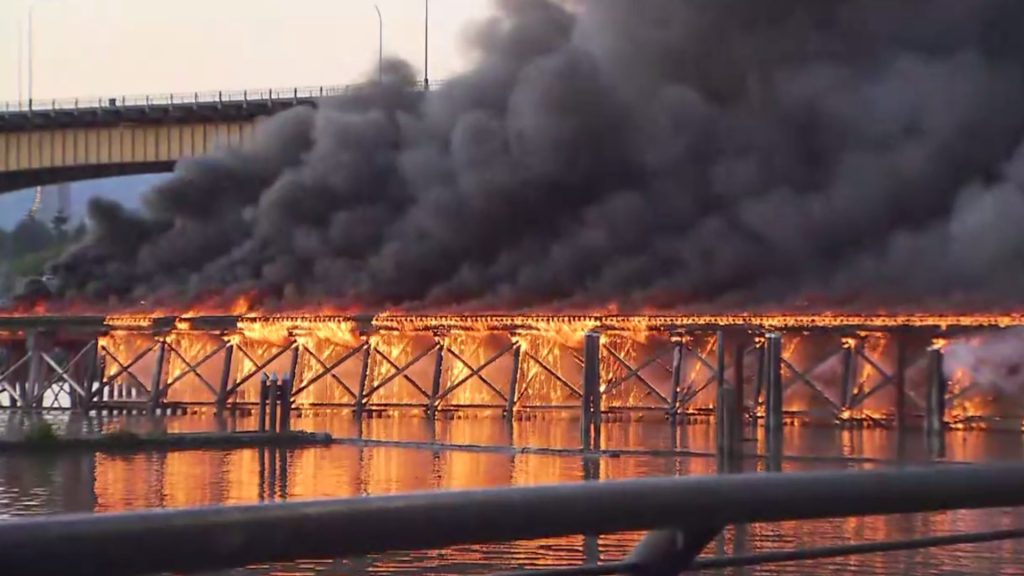 Large fire engulfs inactive rail bridge next to the Oak Street Bridge