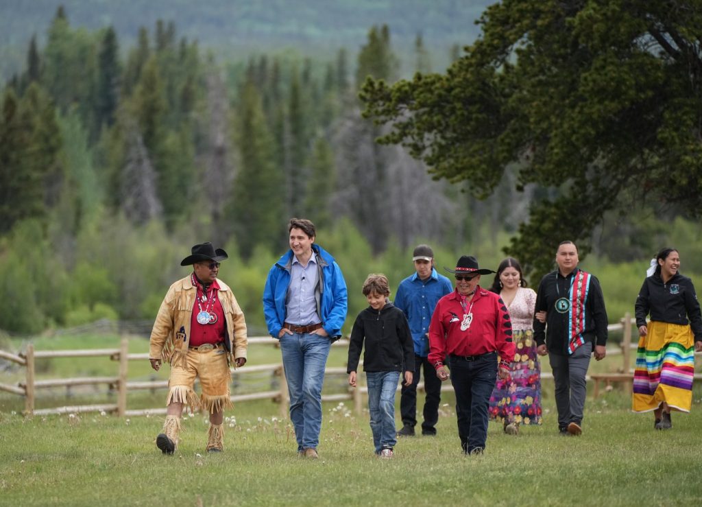 Prime Minister Justin Trudeau, second left, and his son Hadrien, 10, walk with Chief Roger William, left, and Chief Otis Guichon, front right, as they arrive for community celebrations to mark the 10th anniversary of the Tsilhqot'in decision, in Nemaiah Valley, B.C., on Wednesday, June 26, 2024. In 2014, the Supreme Court of Canada granted Tsilhqot'in aboriginal title to more than 1,750 square kilometres of land in the Nemaiah Valley.