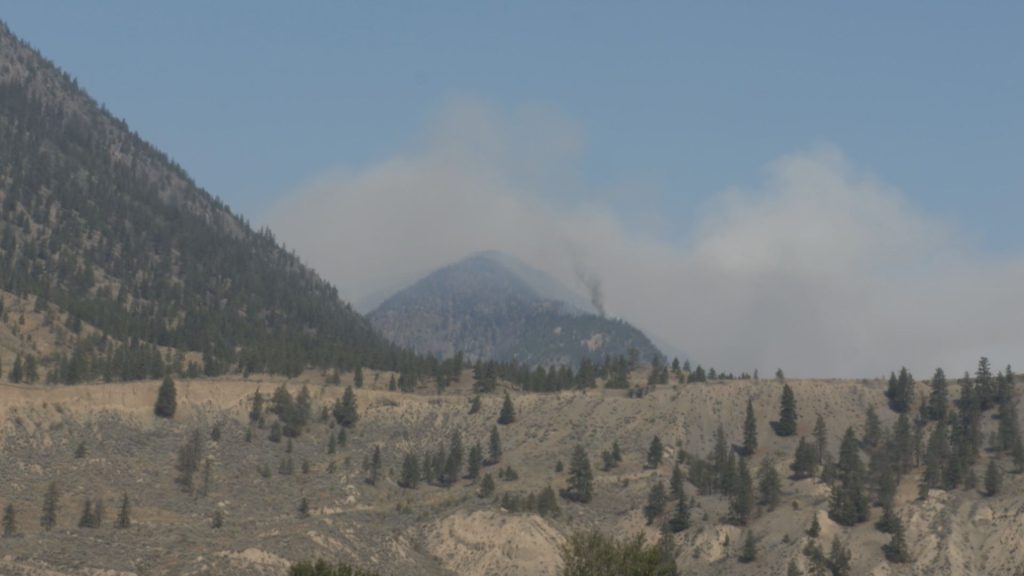 A wildfire is seen in the distance from Spences Bridge, B.C. on Wednesday July 17, 2024.