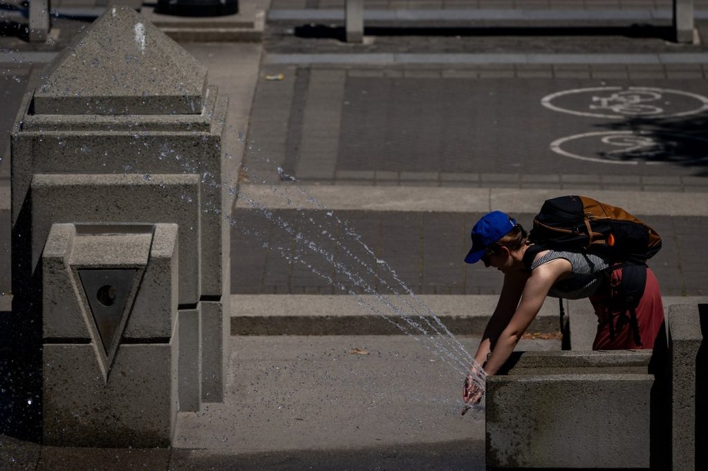 A person cools off at a spray park in Vancouver, Sunday, July 7, 2024. More than two dozen daily temperature records have fallen in British Columbia, with temperatures forecast to remain in the high 30s for the rest of the week in much of the southern Interior.