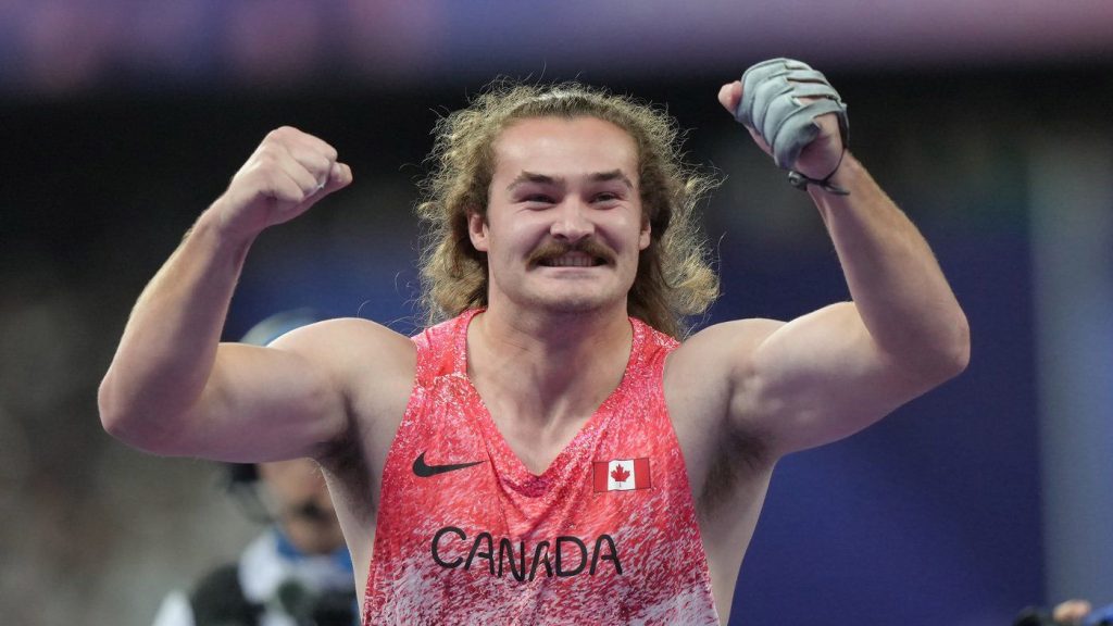 Ethan Katzberg, of Nanaimo, B.C., celebrates after winning gold in the men's hammer throw event at the 2024 Summer Olympics, Sunday, Aug. 4, 2024, in Saint-Denis, France.