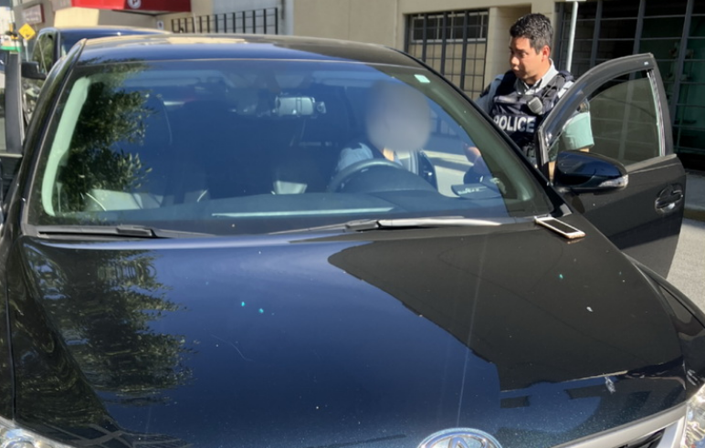 A Richmond RCMP officers stops a driver who is allegedly operating a ride-hailing service without the appropriate licence.