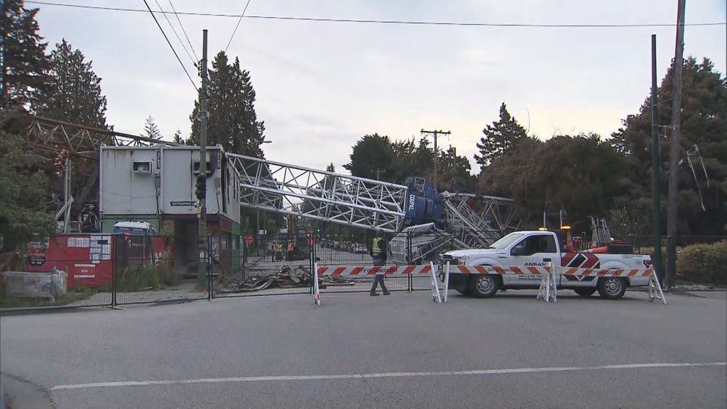 A crane that fell during a fire on Aug. 6, 2024, in Vancouver's Dunbar-Southlands neighbourhood is pictured laying across W. 41st Avenue on Wednesday, Aug. 21, 2024.