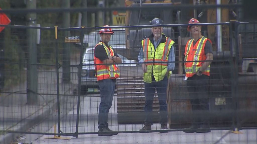 Crews around the site of a crane that fell during a fire on Aug. 6, 2024 in the Dunbar area of Vancouver