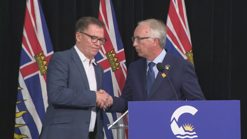 BC United Leader Kevin Falcon shakes the hand of Conservative Party of BC Leader John Rustad at a press conference in Vancouver on Wednesday August 28, 2024.