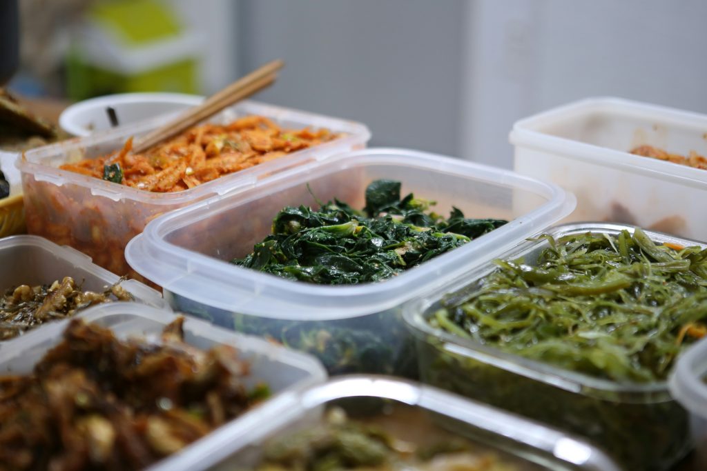 Several plastic containers of stewed vegetable dishes