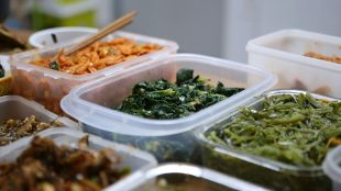 Several plastic containers of stewed vegetable dishes