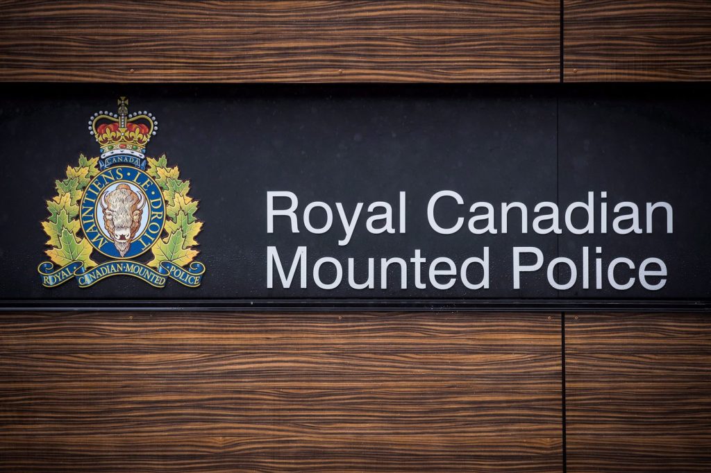 The RCMP logo is seen outside Royal Canadian Mounted Police "E" Division Headquarters, in Surrey, B.C., on April 13, 2018. A Chilliwack, B.C., woman has been arrested over what police say was racially offensive social media content online.