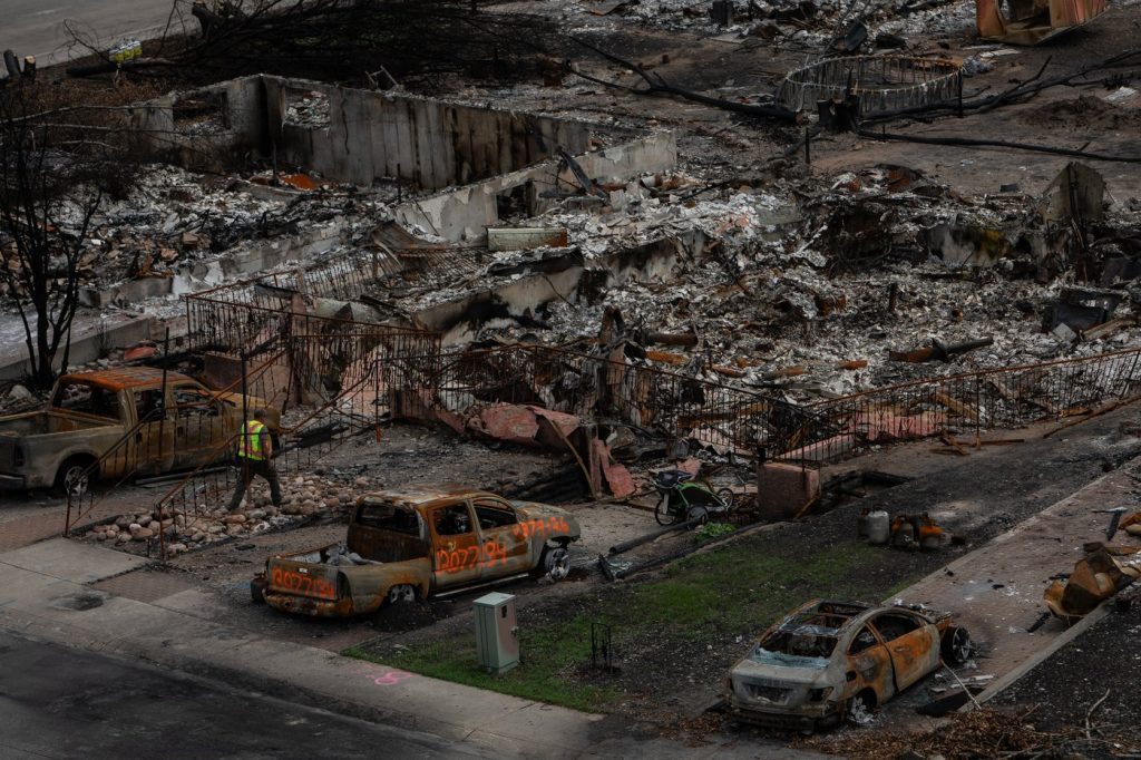 A worker walks in a devastated neighbourhood in west Jasper, Alberta on Monday August 19, 2024. The Insurance Bureau of Canada says the wildfire that tore through Jasper is the second-most expensive one in Alberta's history for insured losses.