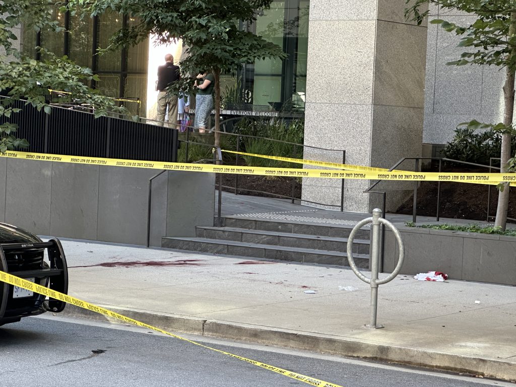 Police tape has been set up blocking off a portion of the Queen Elizabeth Theatre plaza, near the box office. A white tent is also set up, covering what looks to be a body. A pool of blood can be seen nearby on the sidewalk. (CityNews Image / Mike Lloyd)