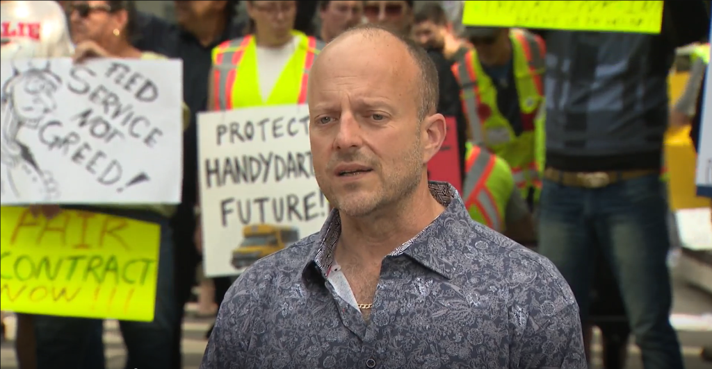 Joe McCann stands before a crowd of protestors