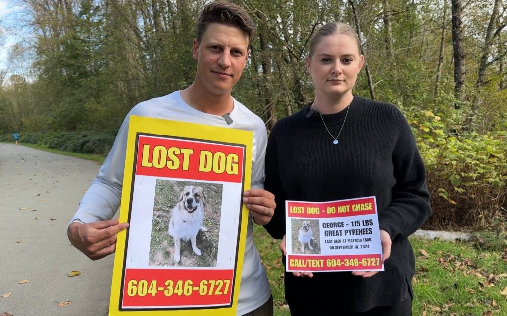 The Gildings pose for a photo, holding posters for their missing dog