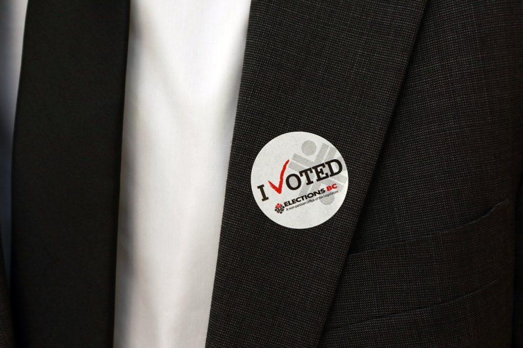 A man wears an I Voted sticker at the Elections BC office in Victoria, B.C., on Sept. 25. Voters in British Columbia — at least those who are not among the one million people who already voted in advance — are going to the polls today to elect the next provincial government in a tight race between New Democrats and Conservatives. THE CANADIAN PRESS/Chad Hipolito