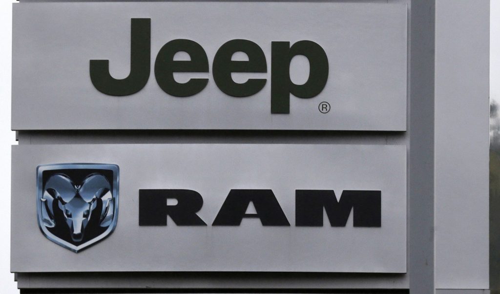 This Oct. 1, 2014 photo shows Jeep and Dodge Ram logos on signs at a dealership in Haverhill, Mass.