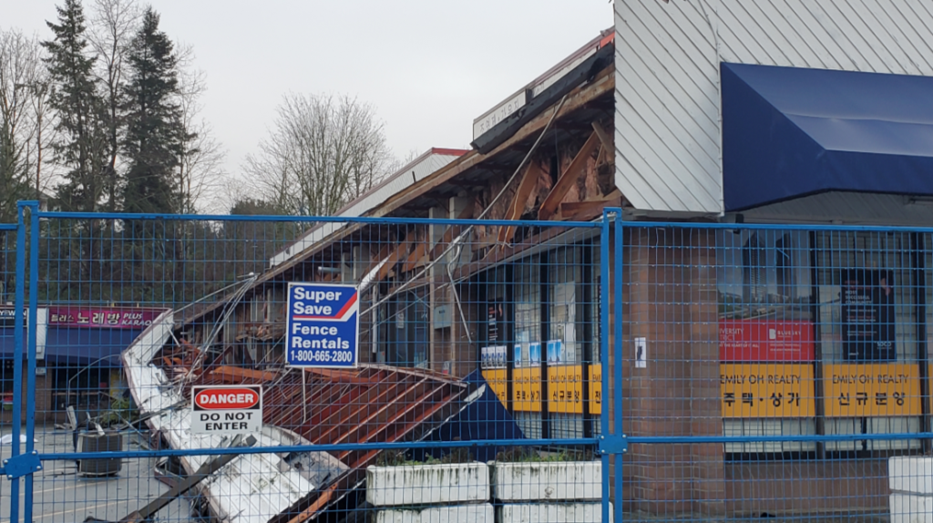 A Coquitlam strip mall remains fenced off on Jan. 5, 2025, a week after a destructive fire.