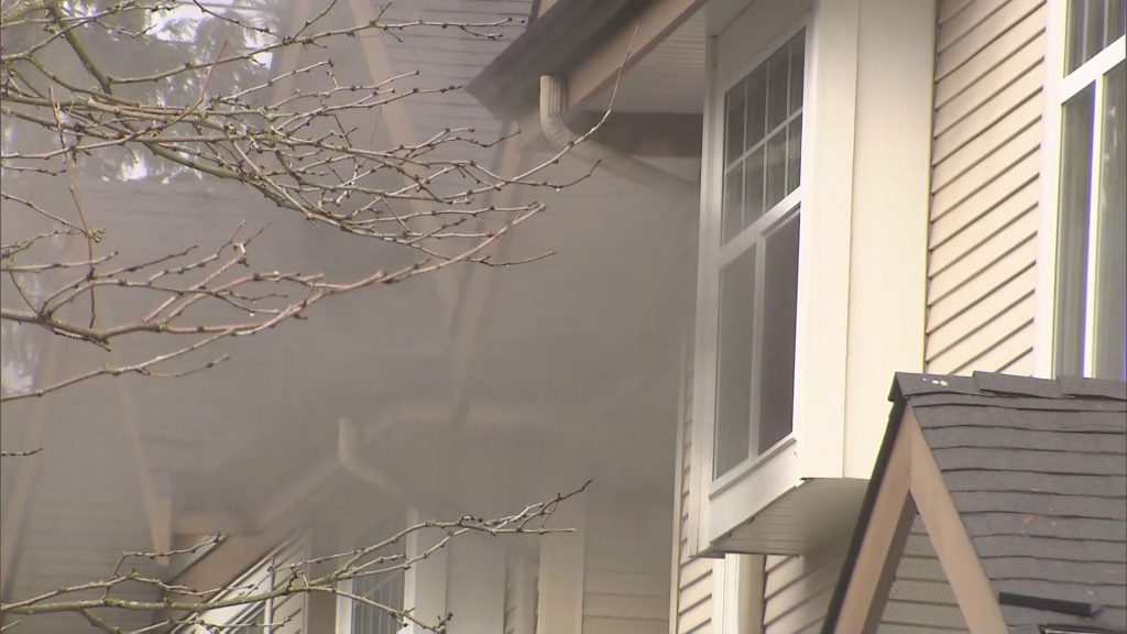 Smoke pours out of a window