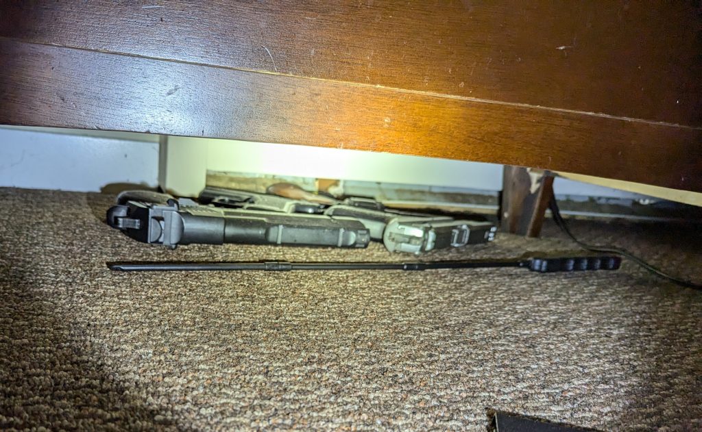 Multiple firearms are seen under furniture
