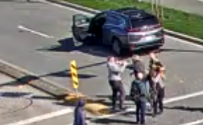 A CCTV image shows  several people, apparently in conflict, near an open SUV