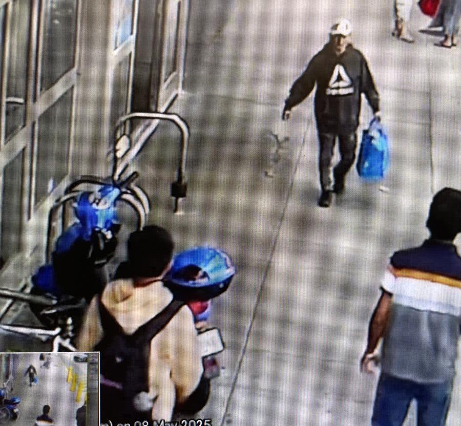 The suspect, captured on CCTV, is described as a man between the ages of 30 and 50, 5'7" tall, with a slim build. At the time, he was wearing black shoes, dark pants, a grey hoodie with a 'Reebok' triangle-shaped logo and lettering on the front, a white baseball cap, and sunglasses.