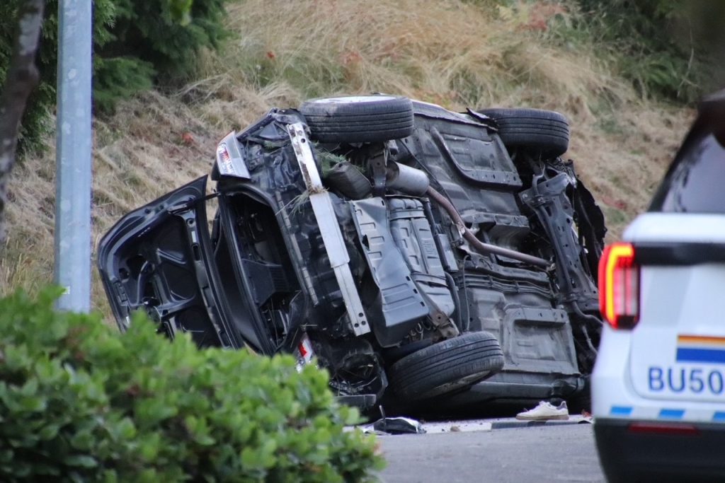 Photos from the Burnaby Mountain crash scene show a badly damaged vehicle, with debris strewn across the roadway. (Credit: 1st Due Media)
