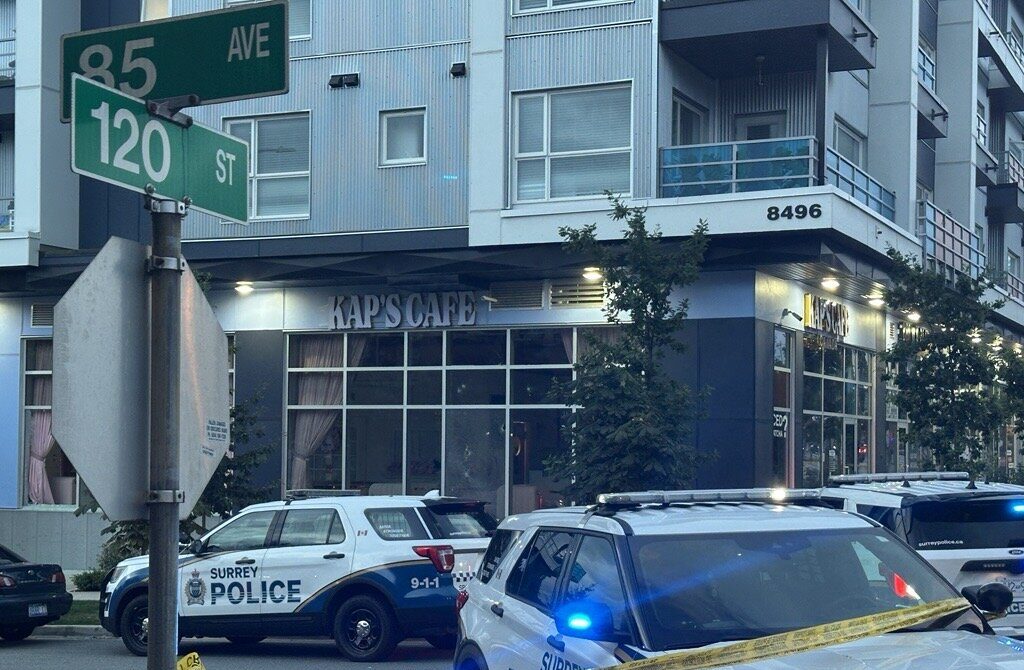 Police surround the exterior of Kap's cafe