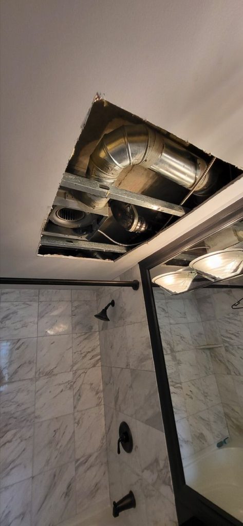 An access hole carved into a bathroom ceiling