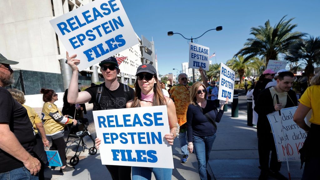 Demonstrators hold signs asking for the release of the Epstein files during a "No Kings" protest in downtown Las Vegas Saturday, Oct. 18, 2025. (Steve Marcus /Las Vegas Sun via AP)
