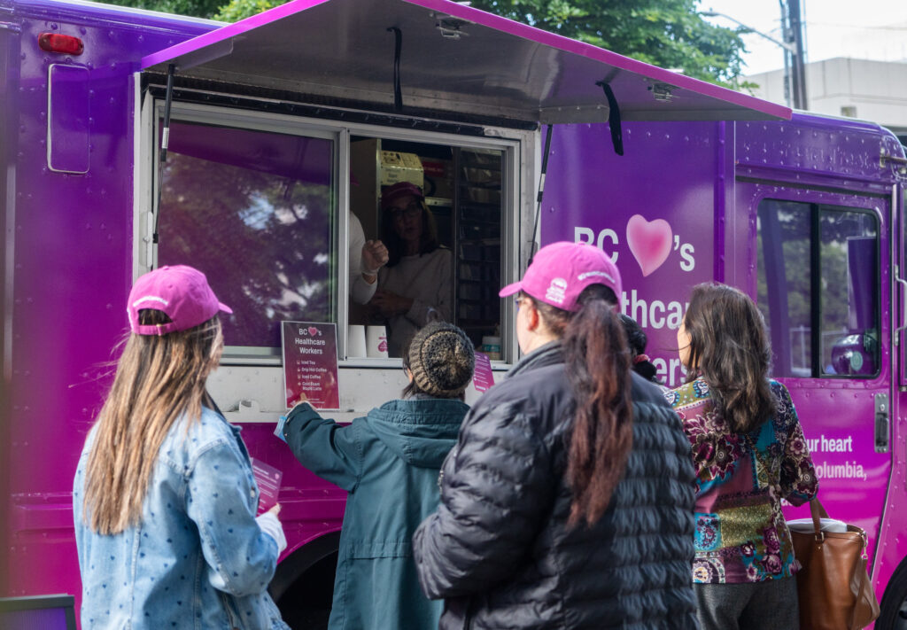 People are seen outside a food truck