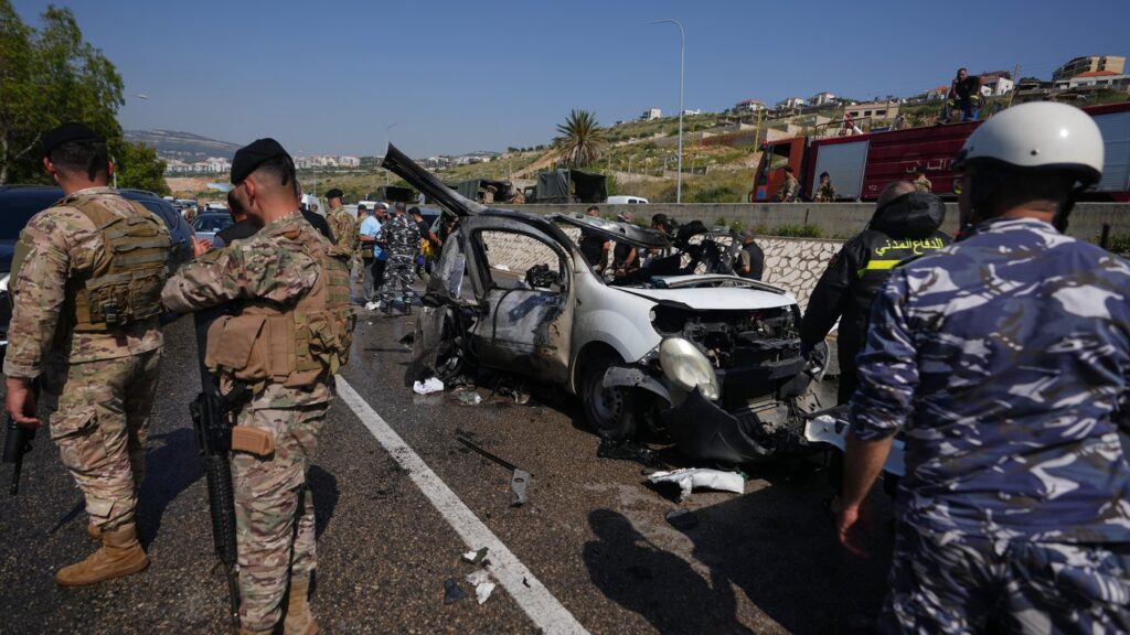 Security forces and emergency responders gather around a damaged vehicle at the scene of an Israeli airstrike that hit a car in the coastal town of Saadiyat, south of Beirut, Lebanon, Saturday, May 9, 2026. (AP Photo/Hassan Ammar)