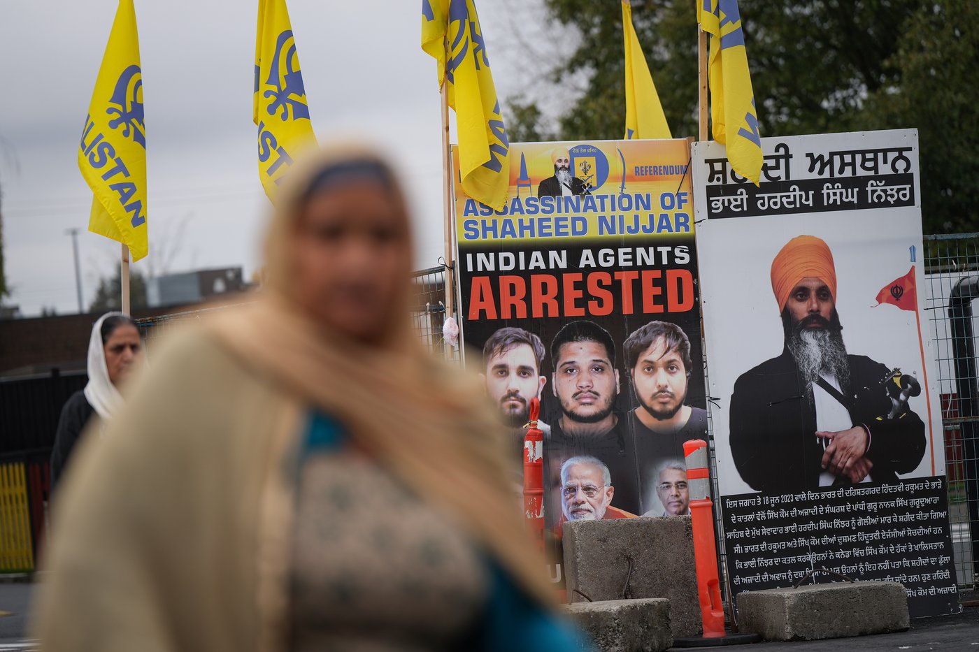 A photo of the late head of the Sikh temple Hardip Singh Nijjar, right behind him, taken outside the Gur Nānāk Sikh Gurdwara Sahib in Surrey, British Columbia, on Tuesday, October 15, 2024. Hardip Singh Nijjar was killed last year in his car when he was leaving the parking lot at the temple. CANADIAN PRESS/Darryl Dyck